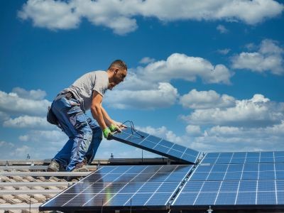 homme sur un toit panneaux photovoltaïques