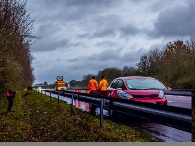 voiture garée lle long de la bande d'urgence de l'autoroute. Dépanneurs conducteur et dépanneuse