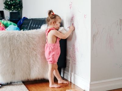 fillette qui dessine sur un mur