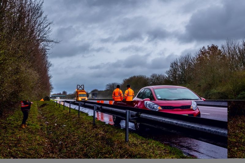 voiture garée lle long de la bande d'urgence de l'autoroute. Dépanneurs conducteur et dépanneuse