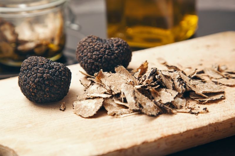 deux truffes et des tranches de truffe sur un eplance en bois