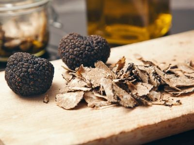 deux truffes et des tranches de truffe sur un eplance en bois